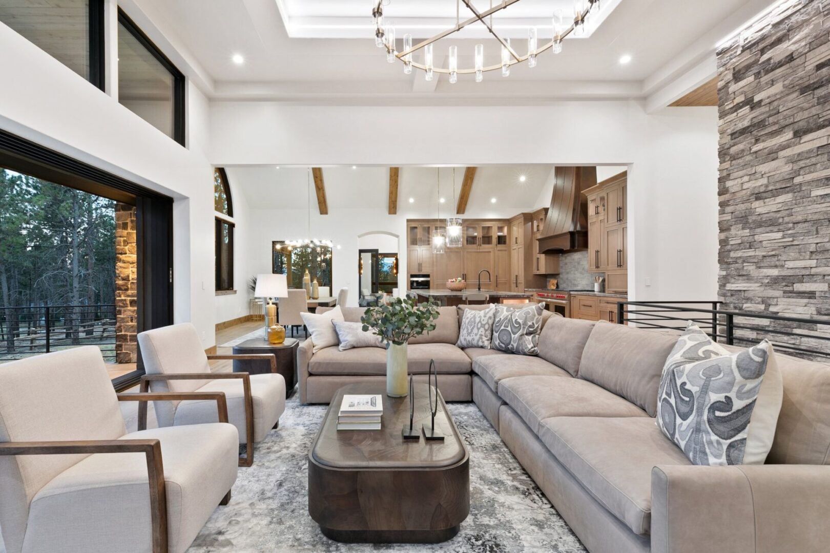Great room with large chandelier, wood ceiling beams and oversized sectional