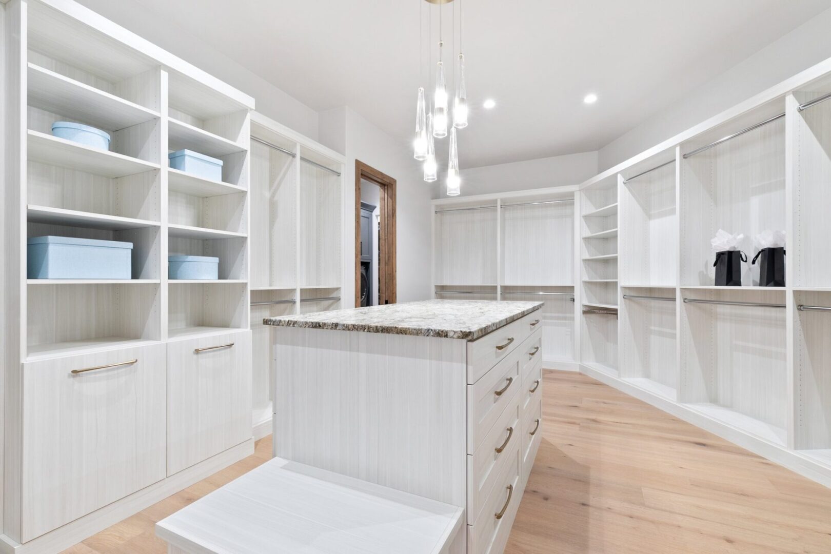 white built-in custom shelving in dressin room closet with large middle island