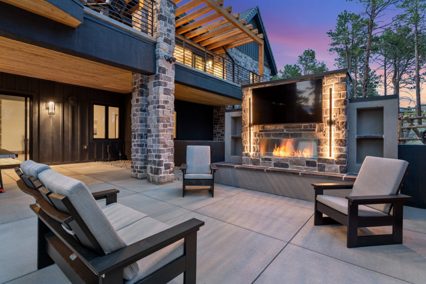 European Modern Estate Outdoor stone built-in fireplace with lighting and TV and patio furniture for outdoor living