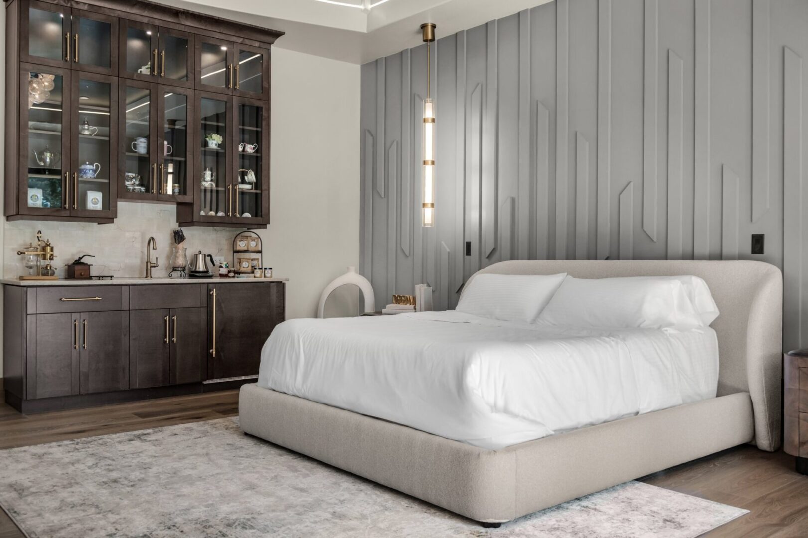 european modern estate primary bedroom with built-in coffee bar and wood trim accent wall.