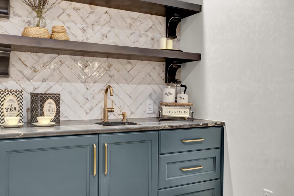 Primary Suite built-in coffee bar with blue cabinets and floating shelving and herringbone backsplash