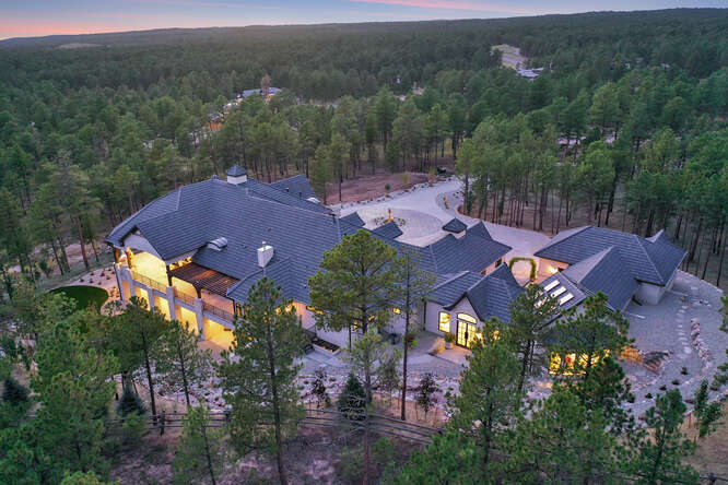 aerial view of home with surrounding forest