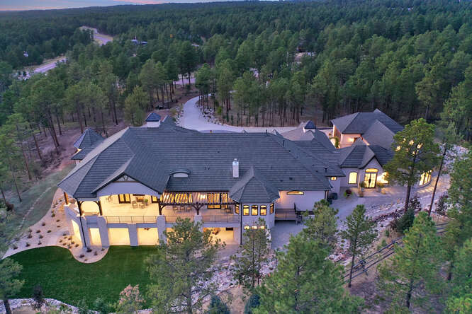 aerial view of home with surrounding forest