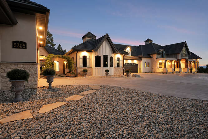 Front Elevation of French Country House with Lights on at dusk