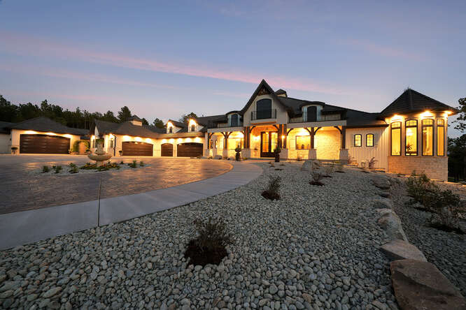 Front Elevation of French Country House with Lights on at dusk