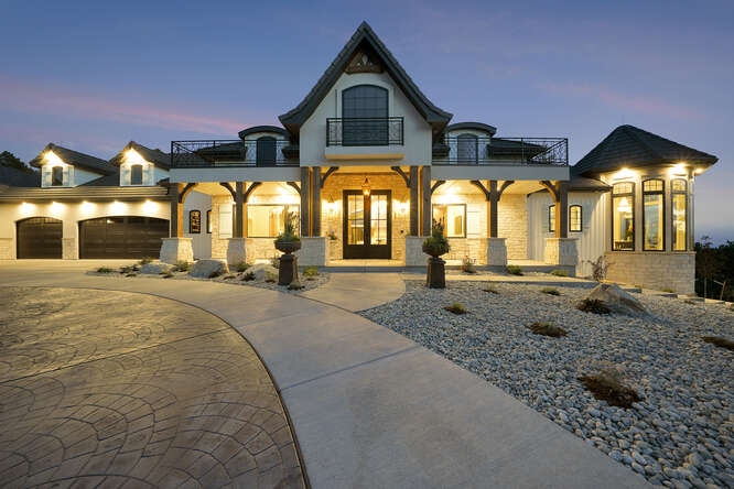 Front Elevation of French Country House with Lights on at dusk