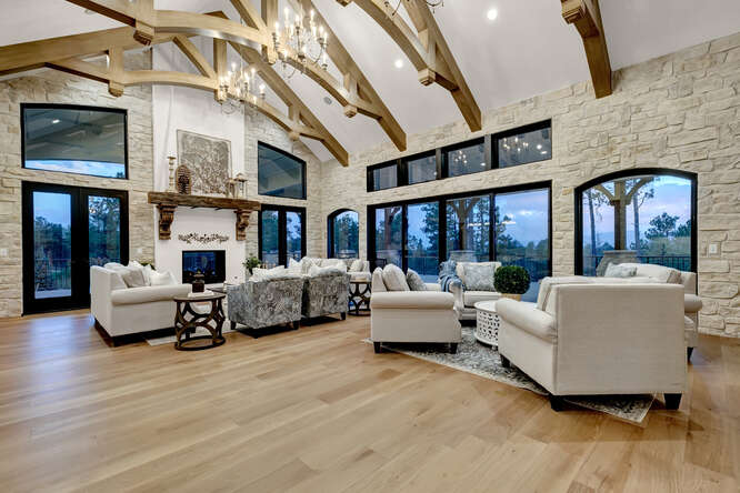 French Country living room with interior wood ceiling trusses and large fireplace