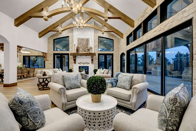 French Country living room with interior wood ceiling trusses and large fireplace