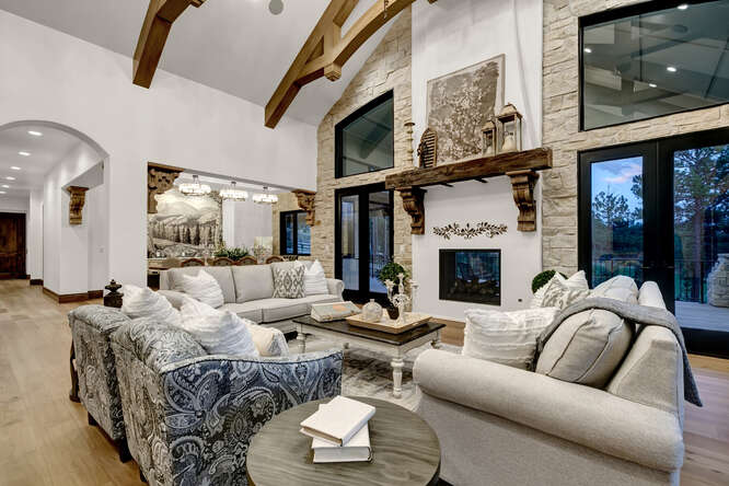 French Country living room with interior wood ceiling trusses and large fireplace