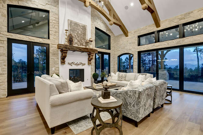 French Country living room with interior wood ceiling trusses and large fireplace