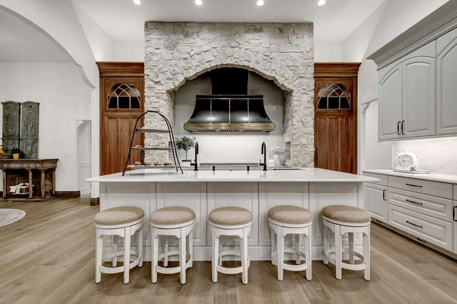 White french country kitchen with large black range hood