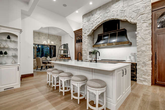 White french country kitchen with large black range hood
