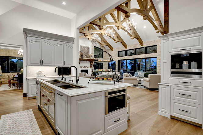 White French Country kitchen cabinets with large island with built-in microwave