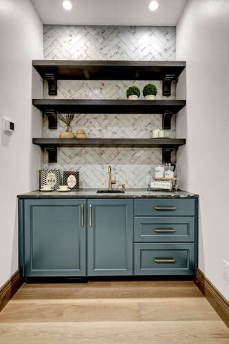Primary Suite built-in coffee bar with blue cabinets and floating shelving and herringbone backsplash