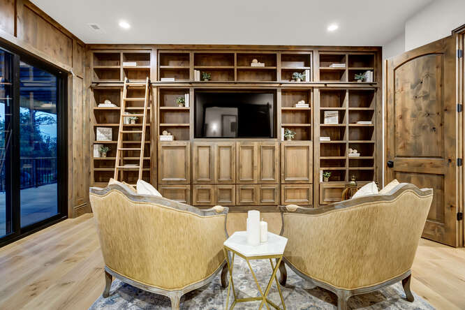 In home library with built-in wood bookshelves and sliding ladder