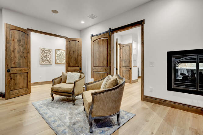 In home library sitting area with 2 accent chairs and a rug