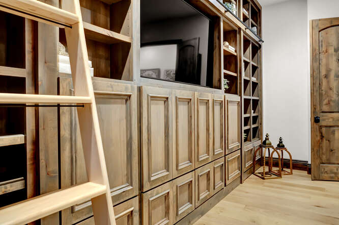 In home library with built-in wood bookshelves and sliding ladder
