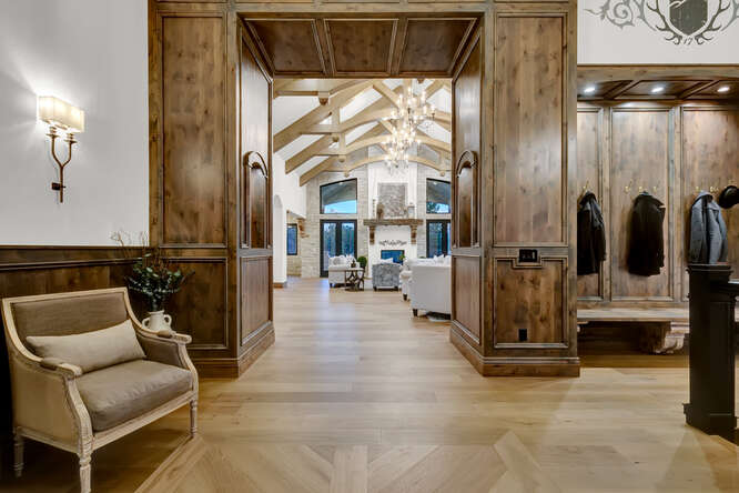 Wood paneling front entry with built-in wardrobe bench with view into living room