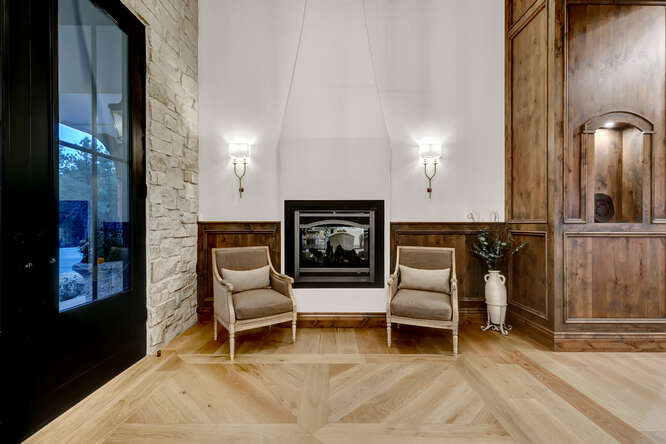 Front entry with double black doors, stone wall and built-in fireplace