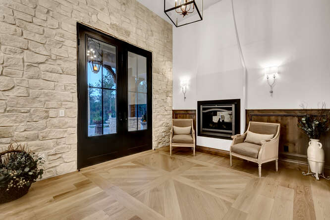 Front entry with double black doors, stone wall and built-in fireplace