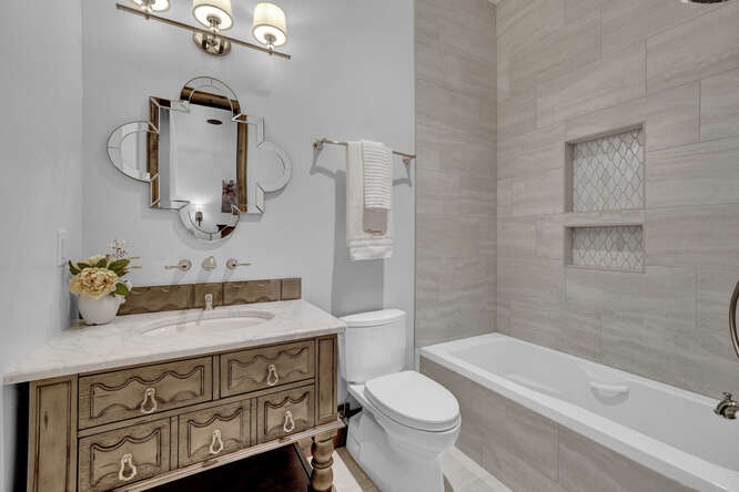 Bathroom with wood vanity and shower/tub combo