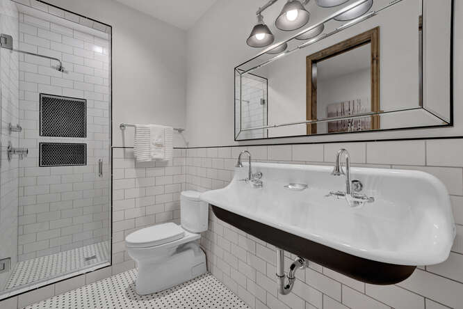 White bathroom with double faucet wide cast iron sink