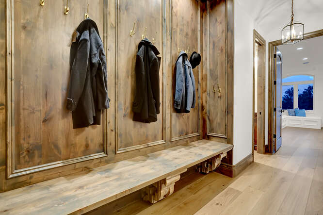 Wood paneled built-in wardrobe bench with coats