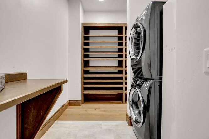 Medium tone built-in closet shelving in Primary Dressing Room Closet and washer/dryer