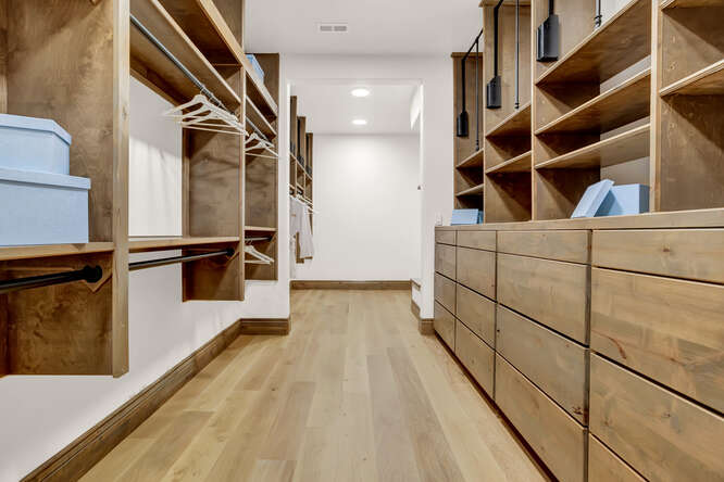 Medium tone built-in closet shelving in Primary Dressing Room Closet