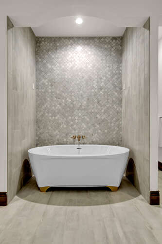 Primary Bathroom with free standing tub and full wall tile