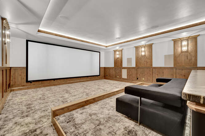 Home theater with wood panel wall and movie screen