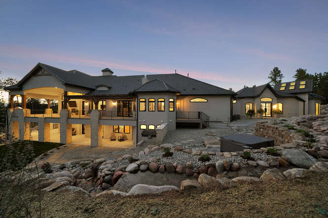 Rear Elevation of large house with tiered rock landscaping
