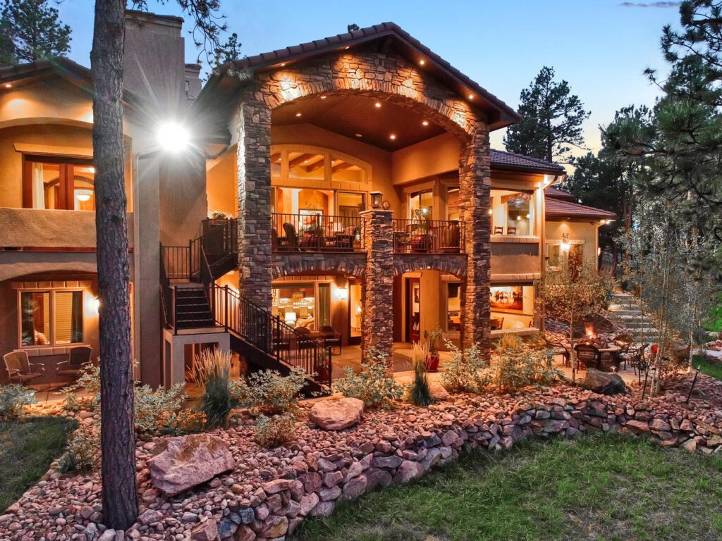 Custom home rear elevation with lights on at dusk captures designing for life