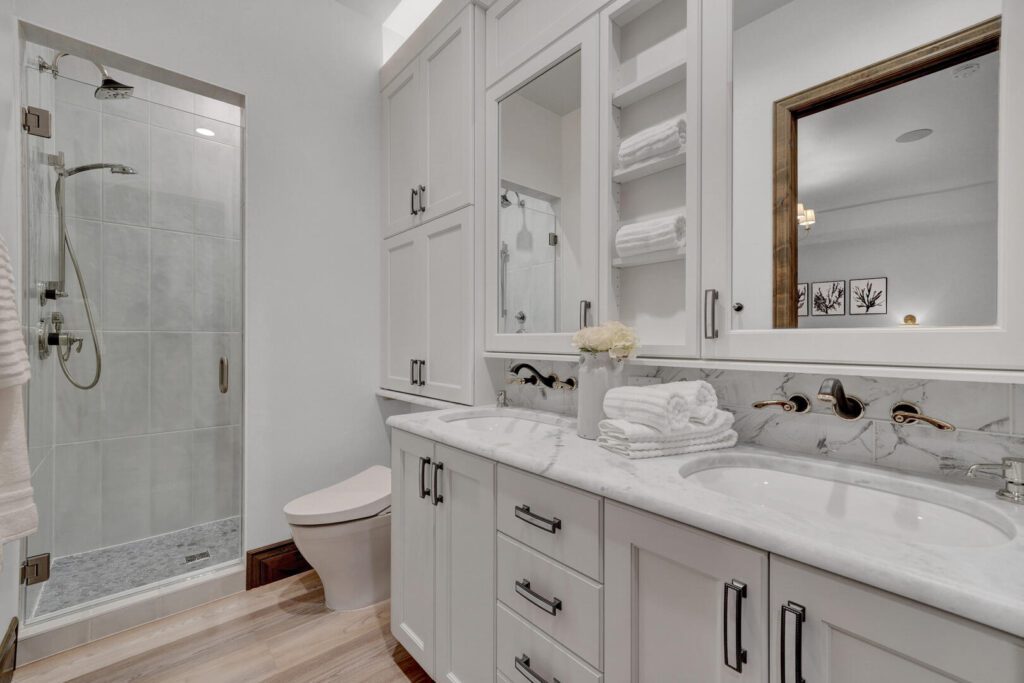 white bathroom with dual sink vanities and white marble counters