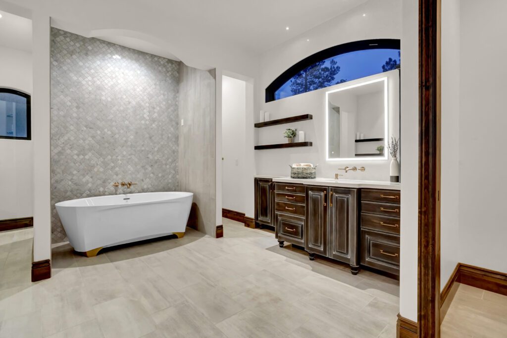 Luxury French Country Primary Bathroom with free standing bath tub and dark stained vanity cabinets with radiant heating in floor