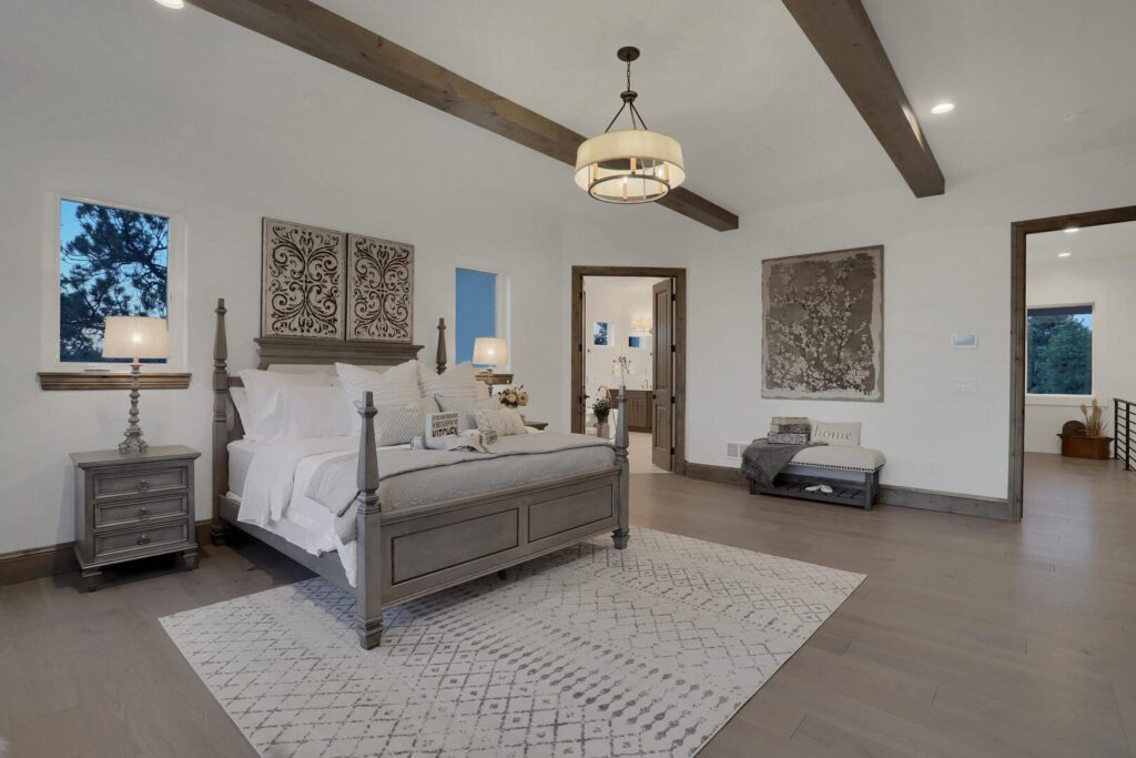 Countryside Craftsman custom home primary suite with wood beam ceiling